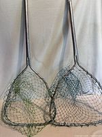 Two medium fish landing nets with metal handles and different colored nets displayed side by side