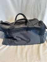 Front and side view of gray duffel showing handles, shoulder strap attachment and overall condition