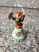 Front view showing Hodori mascot and Olympic rings on bell
