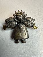 Front view of sterling and brass angel brooch