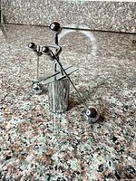 Front view of chrome plated holder with three picks inserted