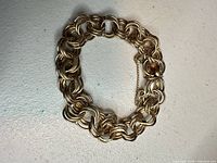 Full view of bracelet laid flat showing overall design and clasp with safety chain