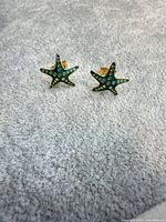 Front view of both starfish earrings showing teal enamel detailing
