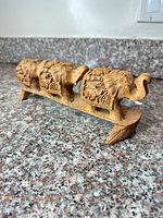 Full view of carved elephant trio on stand