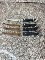 Four stacked steak knives showing full length