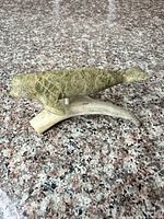 Side view of green soapstone whale on antler base