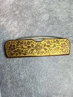 front view of gilded floral metal case