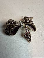 Full view of Monet gold-tone red enamel bow brooch
