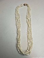 Full view of four-strand pearl necklace showing clasp and length