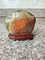 Front view of polished stone on stand showing color variations