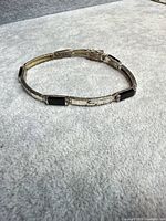 Full view of bracelet showing silver-plated segments and onyx stones