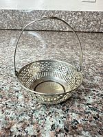 Overall view of sterling silver pierced basket with swing handle upright