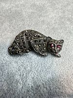 Front view of sterling silver cat brooch showing marcasite and pink rhinestone eyes