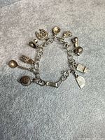 Full view of bracelet and all attached charms on grey background