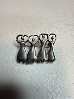 Front view of sterling silver dancers brooch