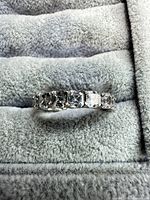 Front view of sterling silver eternity band showing princess-cut CZ stones