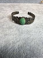 Front view of sterling silver cuff showing turquoise cabochon and stamped designs