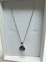 Front view of necklace in display box showing pendant and cable chain