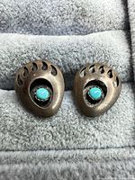 Front view of both bear paw earrings showing turquoise stones and antiqued patina