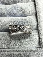 Front view of sterling silver crossover ring showing round stones in both intersecting bands