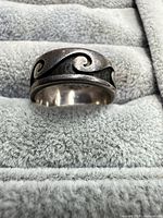 Front view of sterling silver wave motif ring on display pad