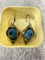 Front view of both earrings showing turquoise cabochons and star design