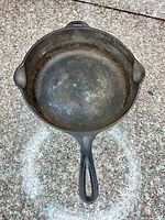 Top view of cast iron skillet showing interior surface and pour spouts