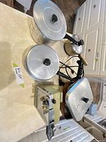 Overall view showing two aluminum pots with lids, small saucepan, electric skillet, Viking can opener