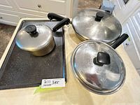 Saucepan on griddle with two covered skillets
