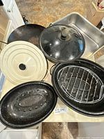 Group shot of all roasting pans, wok, lids and rack