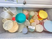 Drawer view of assorted Tupperware containers and lids