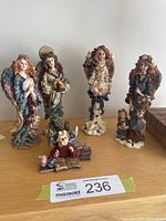 Group shot of four angel figurines and one bear figure