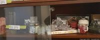 Shelf view with various clear glass and jar candles