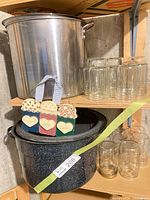 Stainless pot, enamel pot, glass jars, wooden décor on shelf
