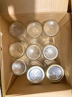 Nine jars arranged mouth up inside cardboard box