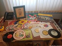Table with various children’s records, framed sketch, puzzles partially visible