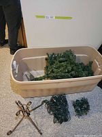 All items: tote holding tree sections and lights, iron stand in foreground