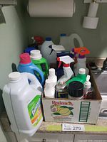 Full view of box with assorted cleaning products on counter