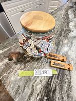 Overview of jar filled with matchbooks, clay ocarina, two wooden train whistles