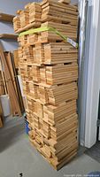 Tall stack of cut 1x4 boards showing quantity and condition
