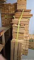 Tall stack of bundled 1×4 wood pieces and surrounding stacks