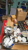Overall view of assorted switches, receptacles, lamp holders, boxed parts, organizer with tools