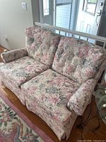 Full view of floral loveseat showing upholstery, cushions, arm covers and skirted base