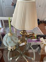 Both lamps shown together on glass table, brass lamp with shade on right, frosted glass touch lamp on left