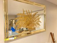 Front view showing entire mirror, gold-tone frame, and floral basket design