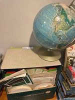 Globe on stand atop Cyclo-Teacher cabinet with discs and folders visible