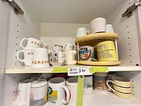 Cabinet showing multiple mugs on two shelves and wooden stacking organizer