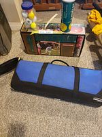 Bocce set box, ladder ball carry case, jar of golf balls, can of tennis balls on floor