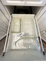 Drawer view showing three clear glass dishes: loaf pan, 9x13 pan, pie plate