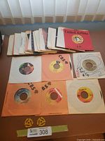 Stack of 45 RPM records with various sleeves and four displayed singles
